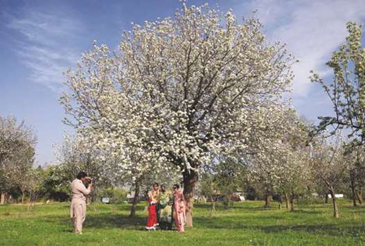 A family takes a picture under flowering and blossoming trees along a roadside in Islamabad. According to the sixth World Happiness Report, Pakistani people are the happiest among all their bordering nations, ahead of its arch-rival India, 11 points ahead of its all-weather friend China, 31 of Iran, and 70 points ahead of Afghanistan on the ranking table of happiness.