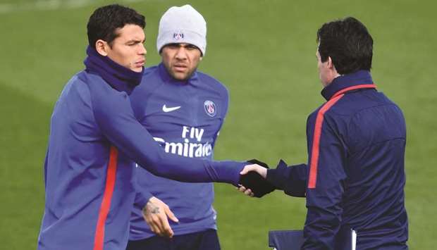 PSG Brazilian defender Thiago Silva (left) shakes hands with head coach Unai Emery as defender Dani Alves looks on during a training session at Saint-Germain-en-Laye, western Paris, yesterday. (AFP)