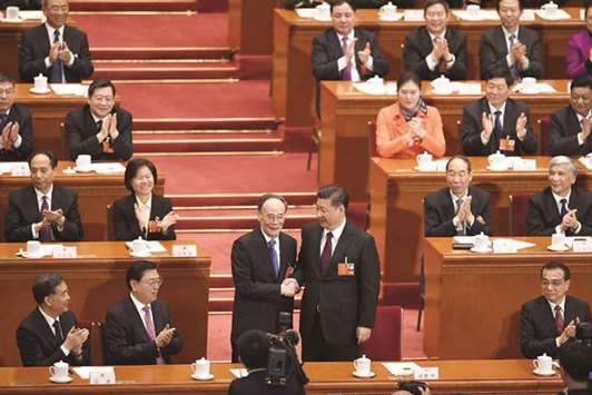 Wang Qishan (left), former secretary of the Central Commission for Discipline Inspection, shakes hands with Chinau2019s President Xi Jinping after Wang was elected as Chinau2019s vice president during the fifth plenary session of the first session of the 13th National Peopleu2019s Congress (NPC) at the Great Hall of the People in Beijing, yesterday.