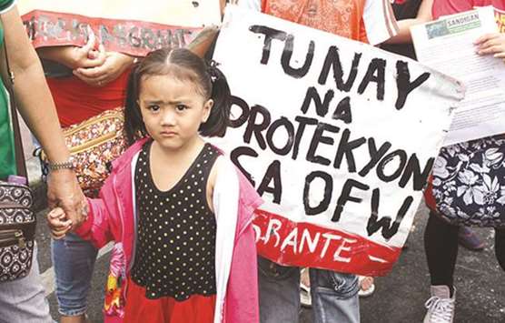 A child appears amidst a group of protesters who held a rally in Mendiola, to demand better protection for overseas Filipino workers.