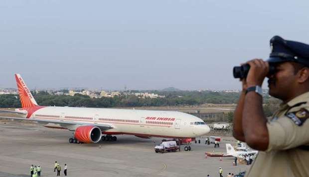 An Indian policeman watches over Begumpet Airport as an Air India Boeing 777 sits on the tarmac