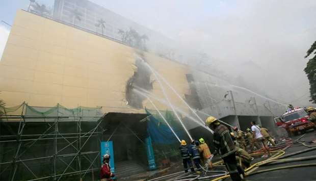 Firefighters douse water after a fire engulfed the Manila Pavilon hotel in Metro Manila