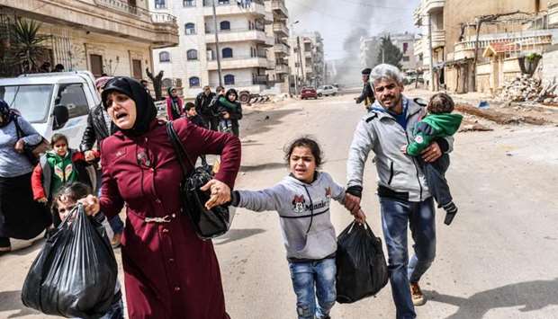 Civilians run cover from explosions in the city of Afrin in northern Syria  after Turkish forces and their rebel allies took control of the Kurdish-majority city.