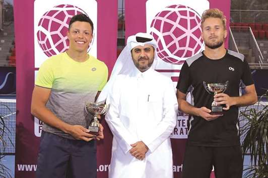 Qatar F3 Futures title winner Jay Clarke of Britain (left) poses with the Qatar Tennis, Squash and Badminton Federation Secretary General Tariq Zainal and runner-up Pietro Rondoni of Italy (right) at the Khalifa International Tennis and Squash Complex.