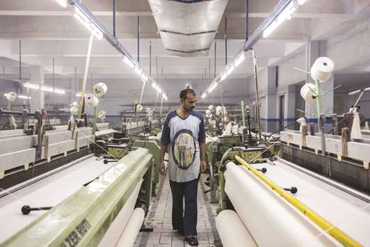 A worker inspects fabric on looms a textile manufacturer in Karachi (file). The Pakistan government plans to enhance to Rs4.5tn the revenue collection target as well as a cut in income taxes in the new federal budget for the new fiscal year, which begins on July 1.