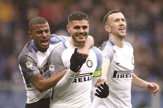 Inter Milanu2019s forward Mauro Icardi (centre) from Argentina celebrates after scoring with Inter Milanu2019s forward Rafinha Alcantara of Brazil (left) and Inter Milanu2019s forward Ivan Perisic from Croatia during the Italian Serie A match against Sampdoria in Genoa yesterday. (AFP)