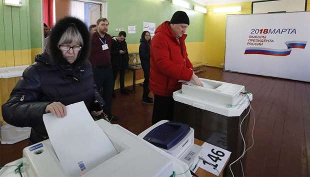 Voters cast their ballots at a polling station during the presidential election in Moscow