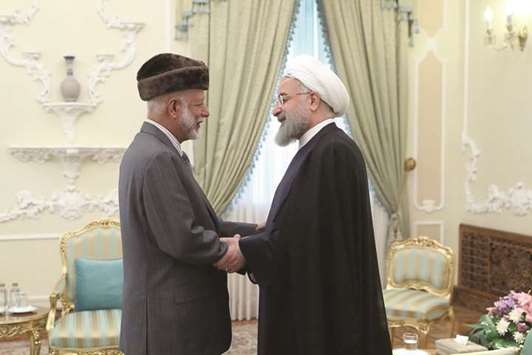 A handout picture provided by the office of Iranian President Hassan Rouhani, yesterday, shows him greeting Omani Foreign Minister Yousef bin Alawi bin Abdullah in Tehran.