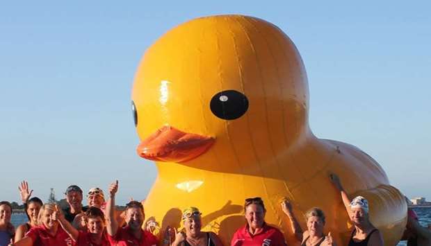 Swimmers posing with a giant inflatable duck they named Daphne in Perth.