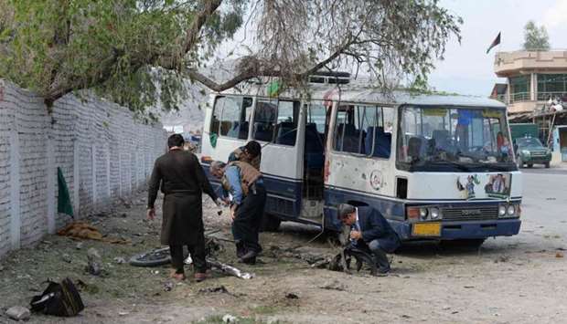 Afghan security personnel inspect the site of bomb blast in Jalalabad