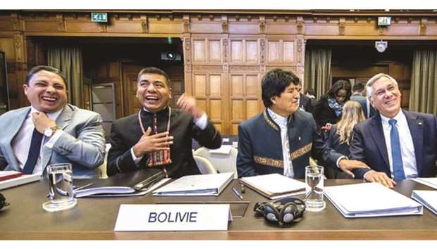 Bolivian President Evo Morales (centre) shares a light moment with officials at The International Court of Justice (ICJ) in The Hague yesterday, where Bolivia and Chile are facing each other in a border conflict.