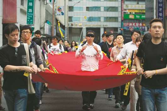 Activists march during the Commemorating Lee Ming-cheu2019s One Year Of Imprisonment Protest in Taipei yesterday.
