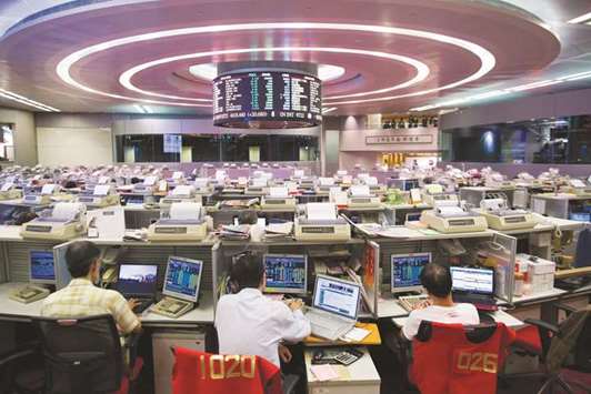 Traders work at the Hong Kong Stock Exchange (file). The Hang Seng closed up 0.1% to 31,549.93 points yesterday.