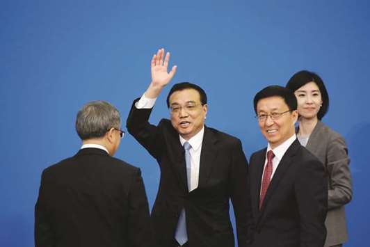 Chinese Premier Li Keqiang waves next to Vice Premier Han Zheng as he leaves the news conference following the closing session of the National Peopleu2019s Congress at the Great Hall of the People in Beijing. Li said China is confident of achieving its 2018 economic targets.