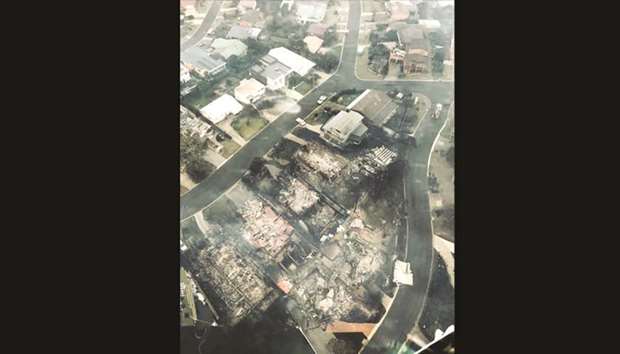 An aerial picture taken through the window of an aircraft by Ou2019Driscoll Aviation shows fires burning in the seaside town of Tathra. Residents got their first look yesterday at the devastation wrought by a bushfire that ravaged a town in Australia, but fears over asbestos and unstable structures mean even those with houses still standing cannot move back.