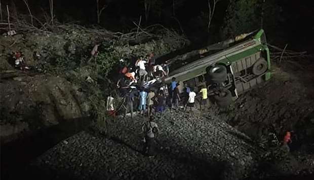 People and rescuers searching for survivors after a passenger bus plunged off a cliff in Sablayan town, Occidental Mindoro province, south of Manila