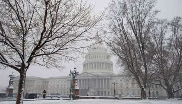 Snow falls at the US Capitol during a snow storm in Washington, DC on Wednesday.