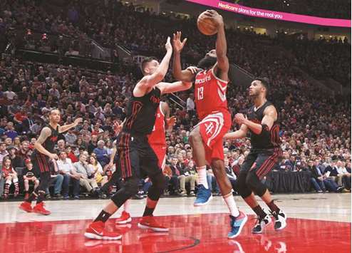 Houston Rockets guard James Harden (centre) shoots over Portland Trail Blazersu2019 Zach Collins (left) and Evan Turner) during the second quarter of the NBA game at the Moda Center in Portland, USA, on Tuesday night. (USA TODAY Sports)