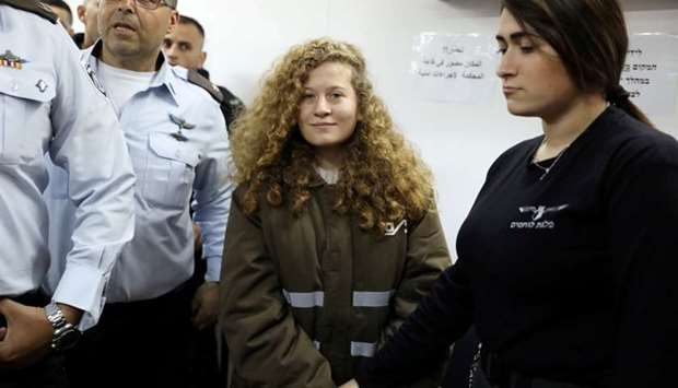 Palestinian teen Ahed Tamimi enters a military courtroom escorted by Israeli security personnel at Ofer Prison, near the West Bank city of Ramallah, January 15, 2018.