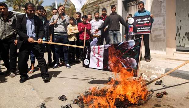 Palestinians burn a dummy representing Palestinian president Mahmud Abbas during a protest in Gaza City on March 21, 2018 against his statement in which he accused Hamas of carrying out a bomb attack against prime minister Rami Hamdallah in Gaza last week, as well as threatening fresh sanctions against them.
