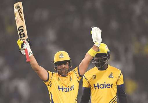 Kamran Akmal (L) of Peshawar Zalmi celebrates after reaching his half-century against Karachi Kings yesterday.