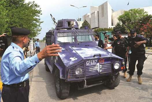 Journalists and security personnel surround the vehicle transporting Rao Anwar as it leaves the Supreme Court.