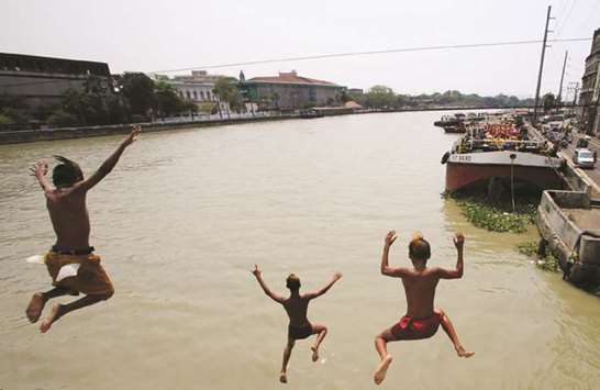 Teenagers dive into the polluted water of Manila Bay ahead of World Water Day in Binondo, Metro Manila, yesterday.