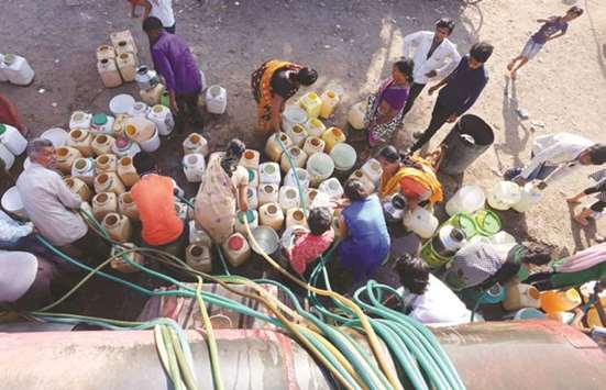 Slum dwellers collect potable water from a municipal water tanker in Durga Nagar area of Bhopal yesterday. Many people in India depend on government supplies for drinking water and struggle to get adequate supply during summer months.