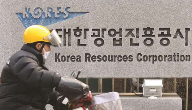 A man rides his motorcycle past a sign for Korea Resources Corporation in Seoul (file). The energy and resources firm is planning a sale of dollar bonds, in a test case of how much market confidence there is that the government will continue to support struggling state-owned companies.