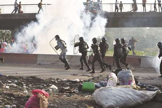 Ivorian riot police throw tear gas to dismantle a rally held by opposition activists in Abidjan yesterday.