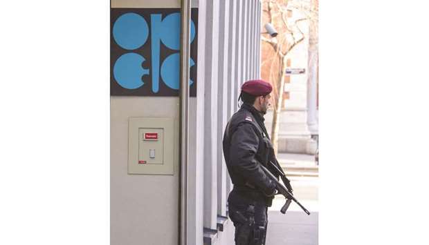 An Austrian policeman guards an entrance to the Opec headquarters during its meeting in Vienna (file). Opec and its allies achieved 138% of pledged output reductions last month, Opec said, up from 133% in January and the highest since the deal aimed at clearing a glut began in January 2017.