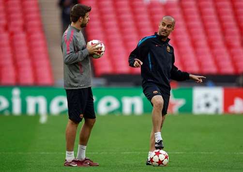 Barcelonau2019s coach Pep Guardiola (right) talks with Gerard Pique during a training session at Wembley Stadium in London on May 27, 2011. (Reuters)