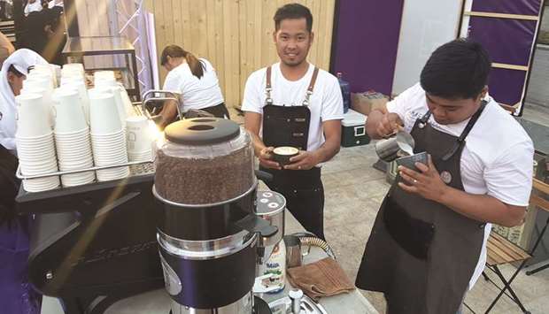 Black Dose coffee (a Qatari start up business) baristas Jay Buan and Jovan Lantion prepare coffee drinks for customers.