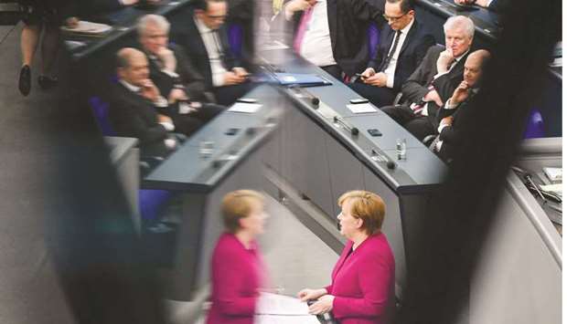REFLECTION: Merkel is reflected as (from left) German Finance Minister and Vice-Chancellor Olaf Scholz, Interior Minister Horst Seehofer, Foreign Minister Heiko Maas, and Economy Minister Peter Altmaier listen while she delivers a speech to parliament in Berlin.