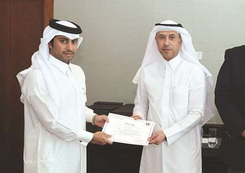 HE the Minister of Administrative Development, Labour and Social Affairs Dr Issa Saad al-Jafali al-Nuaimi handing over a certificate to one of the participants.