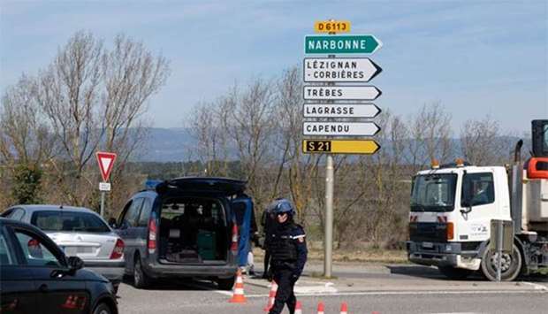 French gendarmes block access to Trebes, where a man took hostages at a supermarket on Friday.
