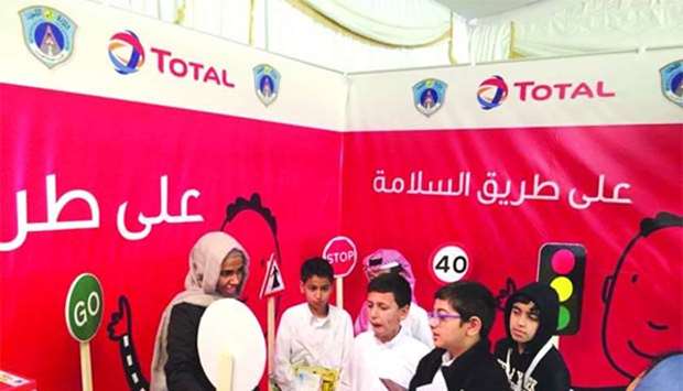 Children participate in a road safety initiative at Total Qatar's booth.