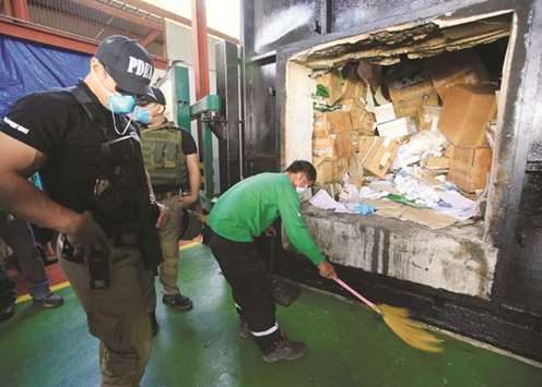Philippine Drug Enforcement Agency (PDEA) operatives stand on guard near confiscated illegal drugs before destroying them through thermal decomposition in Trece Martires, Cavite city, south of Manila, yesterday.