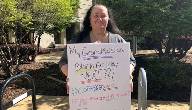 Tami Collins, shows a placard protesting the fatal shooting of Stephon Clark by Sacramento police, during a demonstration in Sacramento, California
