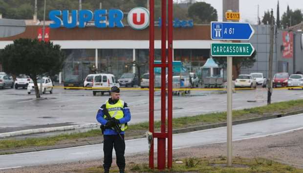A French gendarme secures the access to a supermarket after a hostage situation in Trebes, France.