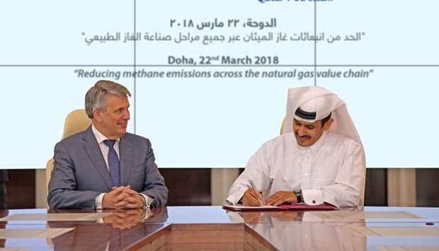 Al-Kaabi signs the 'Guiding Principles' document as van Beurden looks on at a ceremony in Doha on Thursday.