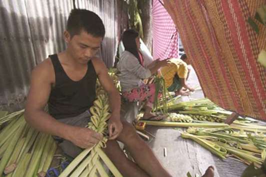 A vendor weaves palm fronds that he will sell in his stall in Manila as Catholics worldwide mark Palm Sunday today, the official start of Holy Week.
