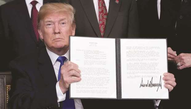 US President Donald Trump holds his signed memorandum on intellectual property tariffs on high-tech goods from China, at the White House in Washington on Thursday. China said it would complain to the WTO about Trumpu2019s import tariffs on steel and aluminium after failing to win an exclusion, which Washington gave to others such as Canada, Australia and the 28-nation EU.