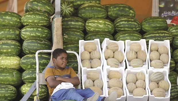A Saudi boy sells melons and watermelons in Riyadh (file). Consumers are not spending heavily in the kingdom to push up prices while many companies are discounting to try to keep market share.
