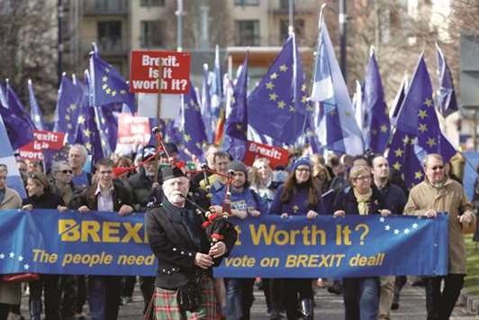 A piper leads protesters waving Saltires and EU flags as they take part in a demonstration to demand a vote on the Brexit deal between Britain and the European Union in Edinburgh yesterday.