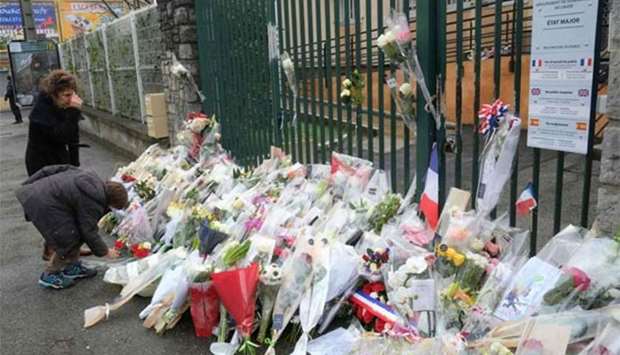 Flowers are laid on Sunday outside the gendarmerie of Carcassonne where slain Lieutenant-Colonel Arnaud Beltrame worked in southwest France, two days after a man carried out an attack in which he and three other people were killed.