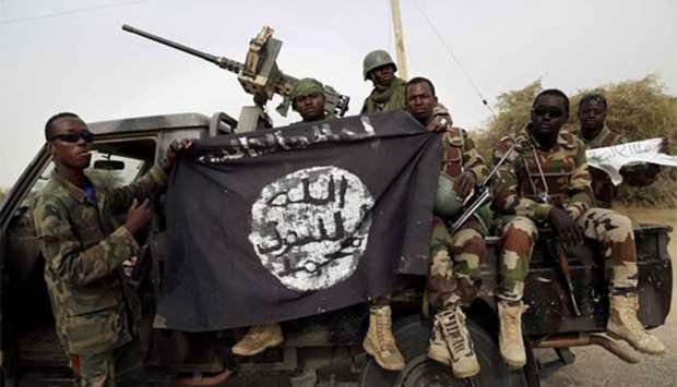 Nigerian soldiers hold up a Boko Haram flag they had seized in Damasak. File picture