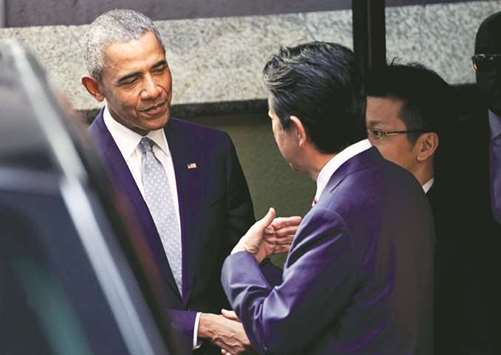 Former US president Barack Obama talks with Japanese Prime Minister Shinzo Abe after having a lunch in front of Japanese Sushi restaurant in Tokyou2019s Ginza shopping district.
