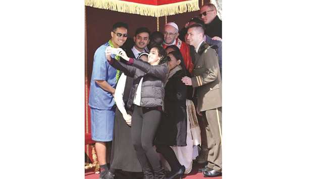 Pope Francis poses for a selfie with youths at the end of the Palm Sunday mass in Saint Peteru2019s Square at the Vatican.