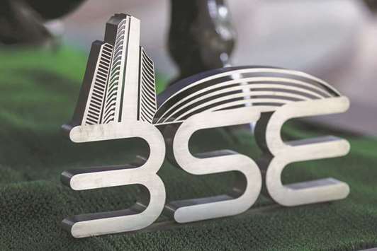 Signage for the Bombay Stock Exchange is displayed next to a bronze bull statue at the entrance to the BSE building in Mumbai. The BSE Sensex closed up 469.87 points to 32,066.41 yesterday.